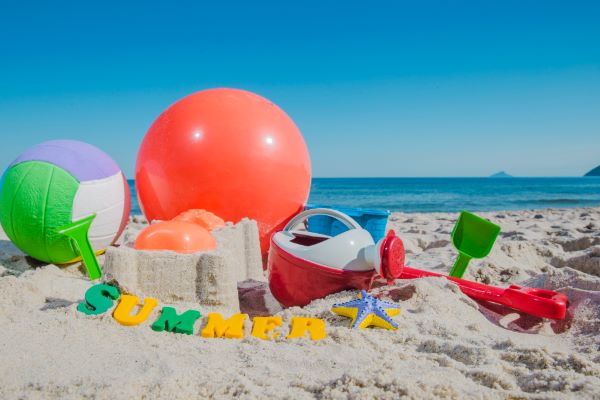 Sandspielzeug und Bälle am Strand